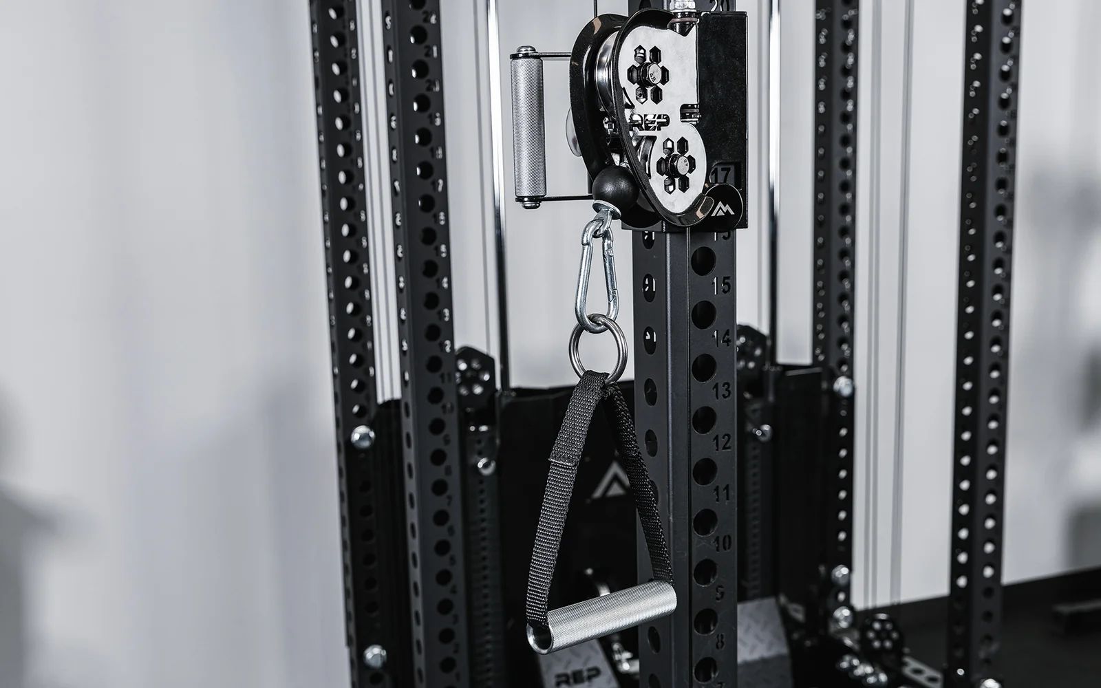 Close-up of a cable pulley and handle on a steel rack